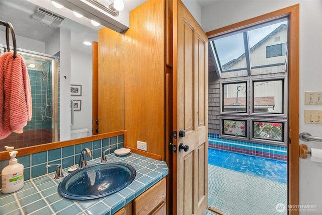 bathroom featuring a shower with shower door, toilet, and vanity