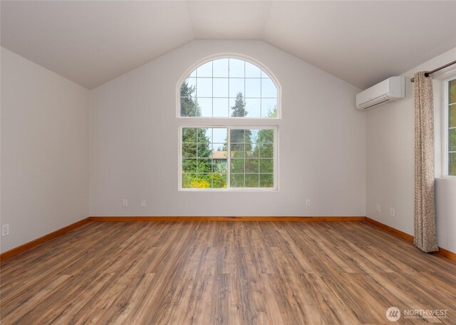 1138 W 17th, Port Angeles, WA 98363 - spare room with a wall mounted AC, wood finished floors, lofted ceiling, and baseboards