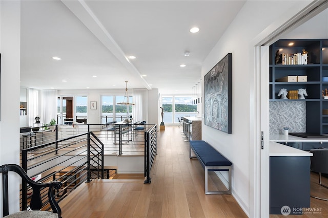 7734 Seward Park Ave S, Seattle, WA 98118 - hall featuring an upstairs landing, a water view, recessed lighting, wood finished floors, and baseboards