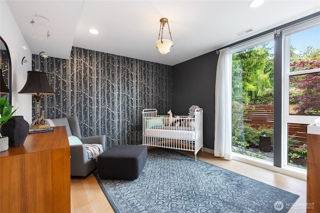 7734 Seward Park Ave S, Seattle, WA 98118 - bedroom featuring an accent wall, wood finished floors, and recessed lighting