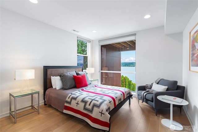 7734 Seward Park Ave S, Seattle, WA 98118 - bedroom with light wood finished floors, recessed lighting, and a water view