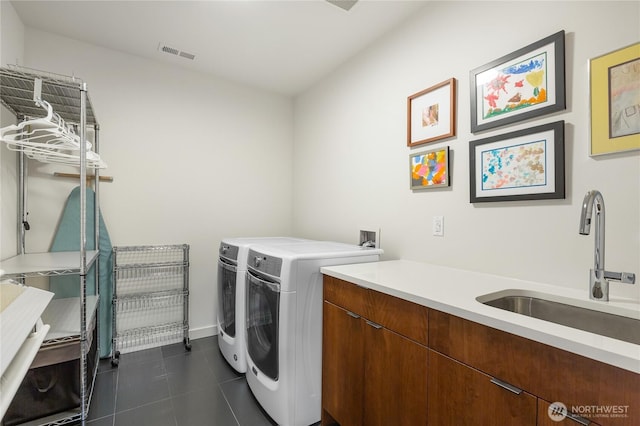 7734 Seward Park Ave S, Seattle, WA 98118 - laundry area with washer and clothes dryer, dark tile patterned floors, and baseboards