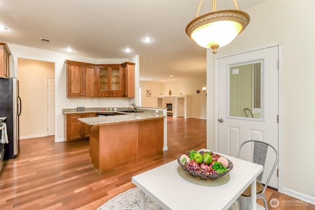 161 Malinka Ln, Chehalis, WA 98532 - kitchen featuring freestanding refrigerator, brown cabinets, a peninsula, a sink, and glass insert cabinets