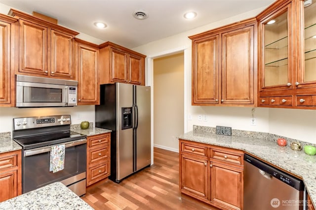 161 Malinka Ln, Chehalis, WA 98532 - kitchen with stainless steel appliances, light wood-type flooring, recessed lighting, brown cabinetry, and glass insert cabinets