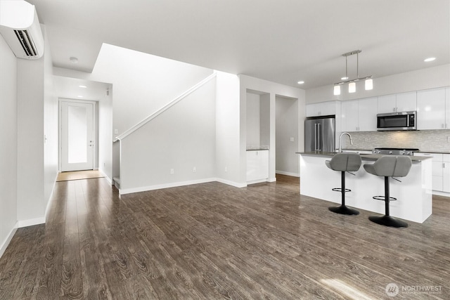 4720 Spring Vista Way, Bellingham, WA 98226 - kitchen featuring stainless steel appliances, dark wood-type flooring, white cabinetry, a wall mounted air conditioner, and decorative backsplash