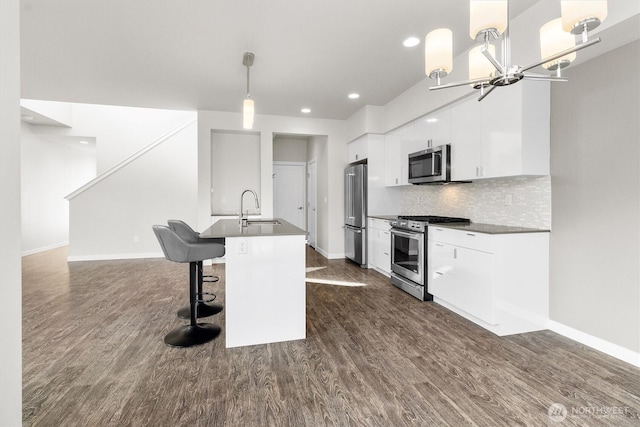 4720 Spring Vista Way, Bellingham, WA 98226 - kitchen with stainless steel appliances, a sink, dark wood-style floors, white cabinetry, and an island with sink