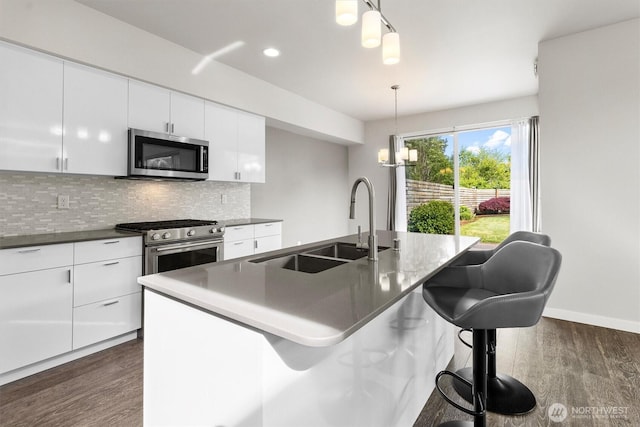4720 Spring Vista Way, Bellingham, WA 98226 - kitchen featuring appliances with stainless steel finishes, a sink, dark wood-type flooring, tasteful backsplash, and white cabinets