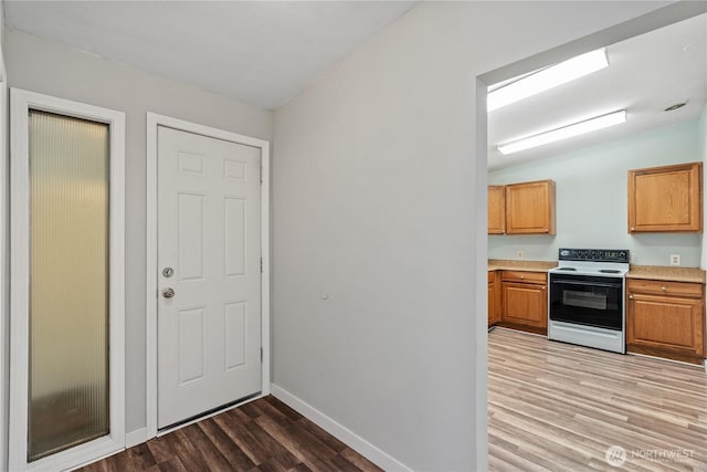 2404 Sumner Ave, Aberdeen, WA 98520 - kitchen with electric range oven, light wood finished floors, light countertops, baseboards, and lofted ceiling