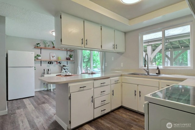 19411 67th St E, Bonney Lake, WA 98391 - kitchen featuring white appliances, a sink, a peninsula, and dark wood-style floors