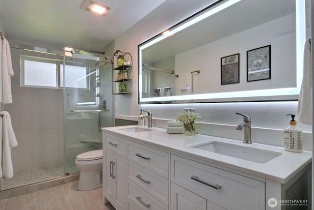 19411 67th St E, Bonney Lake, WA 98391 - bathroom featuring a shower stall, double vanity, toilet, and wood finished floors