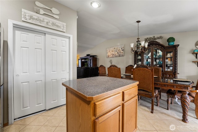 985 S 10th Ave, Othello, WA 99344 - kitchen featuring a chandelier, light tile patterned floors, vaulted ceiling, dark countertops, and a kitchen island
