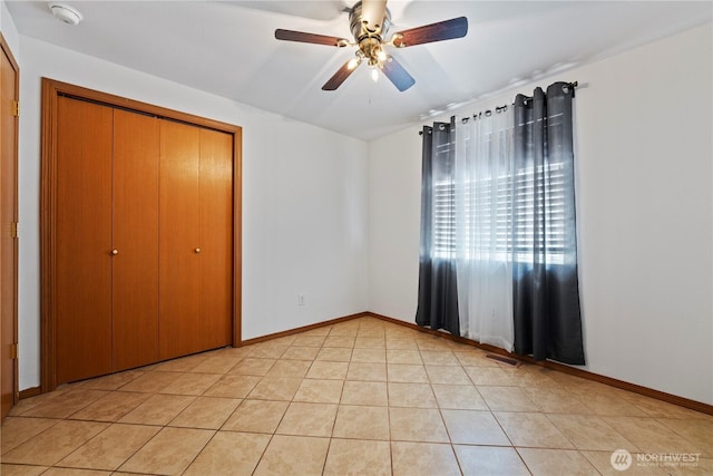 985 S 10th Ave, Othello, WA 99344 - unfurnished bedroom featuring light tile patterned floors, a closet, baseboards, and ceiling fan