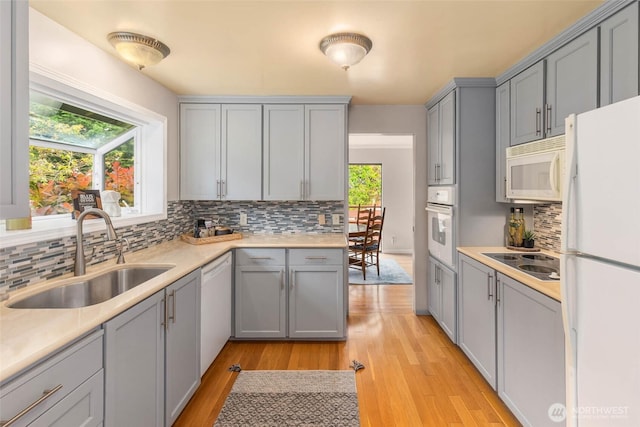 7915 SE 34th St, Mercer Island, WA 98040 - kitchen featuring white appliances, a sink, gray cabinets, light wood-style floors, and backsplash