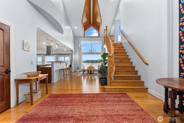 7342 Huckleberry Rd NW, Olympia, WA 98502 - entrance foyer featuring wood finished floors, stairs, a chandelier, baseboards, and track lighting