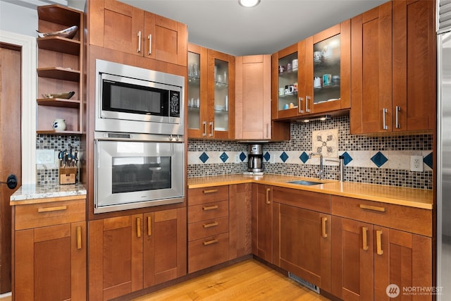 7342 Huckleberry Rd NW, Olympia, WA 98502 - kitchen with stainless steel appliances, light wood finished floors, and brown cabinetry