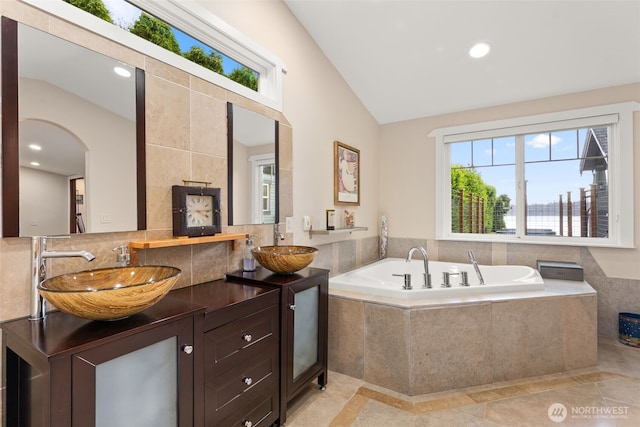7342 Huckleberry Rd NW, Olympia, WA 98502 - full bathroom with vaulted ceiling, double vanity, a bath, recessed lighting, and tasteful backsplash