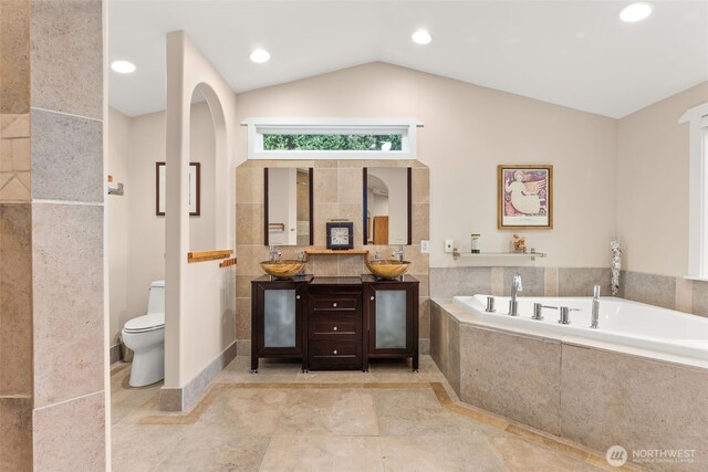 7342 Huckleberry Rd NW, Olympia, WA 98502 - bathroom with a garden tub, double vanity, toilet, vaulted ceiling, and recessed lighting