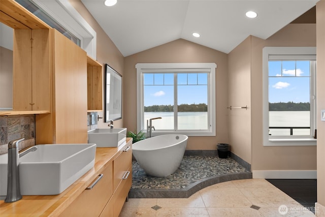 7342 Huckleberry Rd NW, Olympia, WA 98502 - full bath with lofted ceiling, double vanity, a soaking tub, baseboards, and recessed lighting