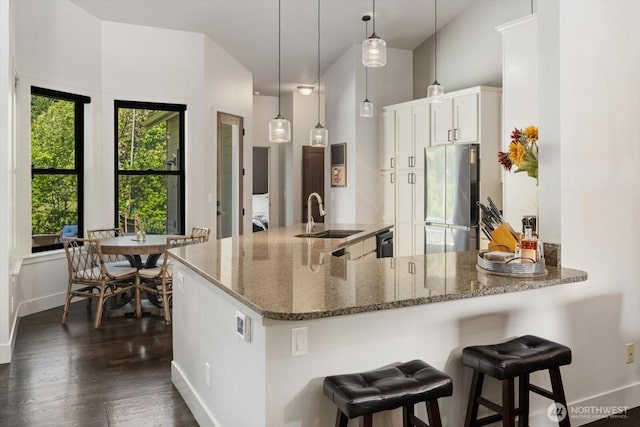 381 Pebble Beach Dr, Cle Elum, WA 98922 - kitchen featuring freestanding refrigerator, a sink, dark wood finished floors, dark stone countertops, and white cabinetry