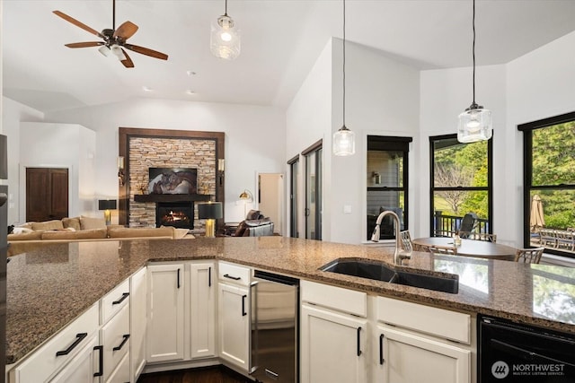 381 Pebble Beach Dr, Cle Elum, WA 98922 - kitchen featuring a sink, dishwasher, open floor plan, a stone fireplace, and lofted ceiling