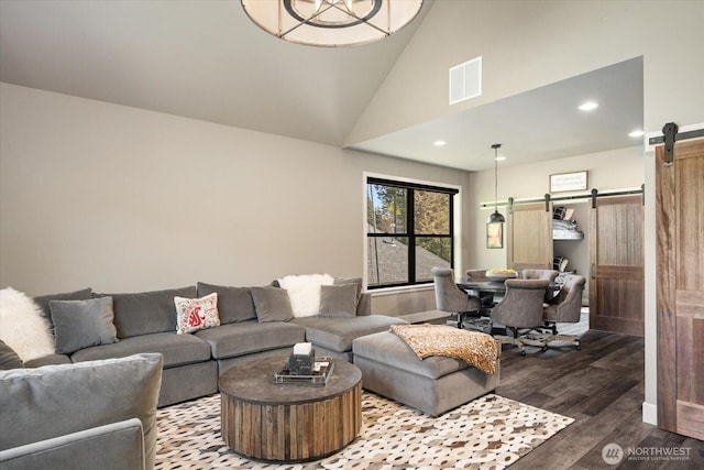 381 Pebble Beach Dr, Cle Elum, WA 98922 - living room with a barn door, wood finished floors, recessed lighting, baseboards, and high vaulted ceiling