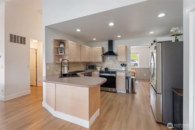 2707 Angel Ln, East Wenatchee, WA 98802 - kitchen featuring stainless steel appliances, wall chimney exhaust hood, light brown cabinets, a sink, and a peninsula