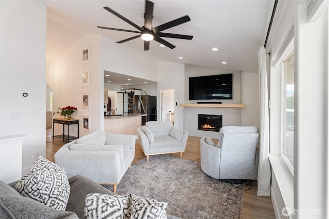 2707 Angel Ln, East Wenatchee, WA 98802 - living area featuring vaulted ceiling, a ceiling fan, a glass covered fireplace, wood finished floors, and recessed lighting