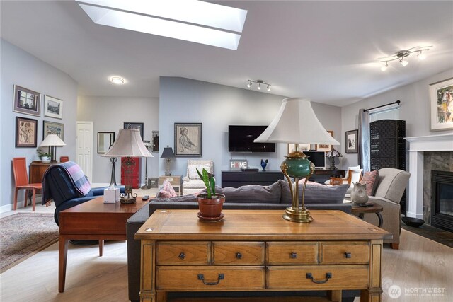 157 Northwood Dr, Point Roberts, WA 98281 - living room featuring a skylight, light wood finished floors, rail lighting, and a tiled fireplace