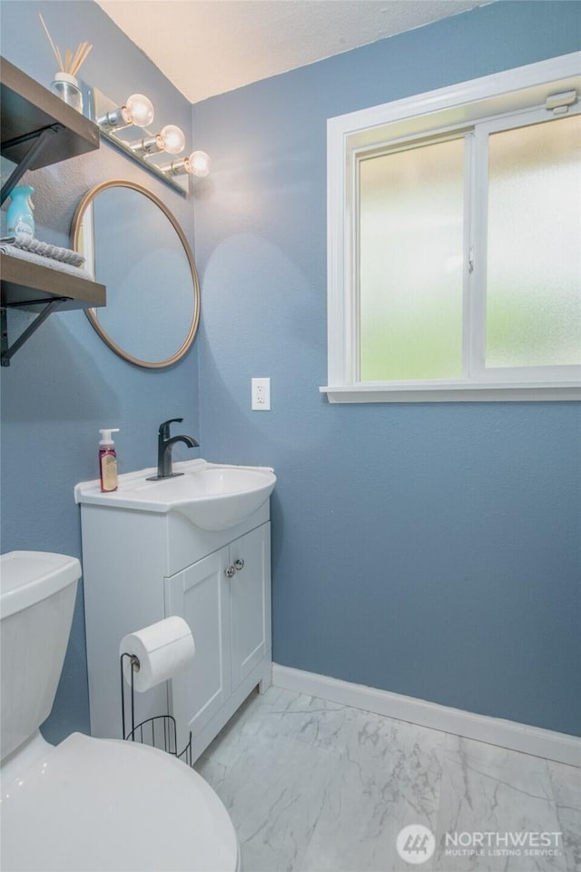 14016 113th Avenue Ct E, Puyallup, WA 98374 - half bathroom featuring marble finish floors, vanity, toilet, and baseboards