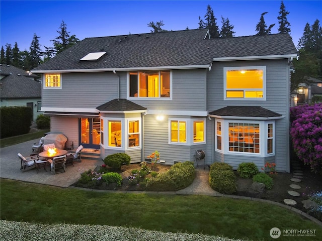2601 59th St SW, Everett, WA 98203 - back of property at dusk featuring a patio, roof with shingles, a fire pit, and a yard