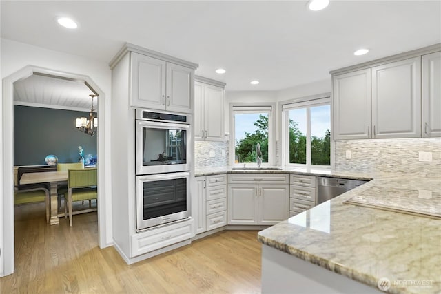 2601 59th St SW, Everett, WA 98203 - kitchen with appliances with stainless steel finishes, a sink, a chandelier, light stone counters, and tasteful backsplash