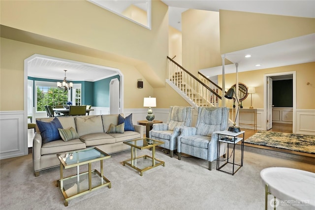 2601 59th St SW, Everett, WA 98203 - living room featuring a chandelier, a wainscoted wall, a decorative wall, stairs, and carpet flooring