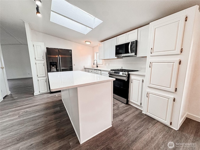 700 N Reed St Unit 72, Sedro Woolley, WA 98284 - kitchen featuring stainless steel appliances, a skylight, lofted ceiling, dark wood-type flooring, and light countertops