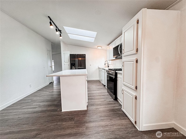 700 N Reed St Unit 72, Sedro Woolley, WA 98284 - kitchen featuring appliances with stainless steel finishes, a skylight, a sink, a center island, and vaulted ceiling