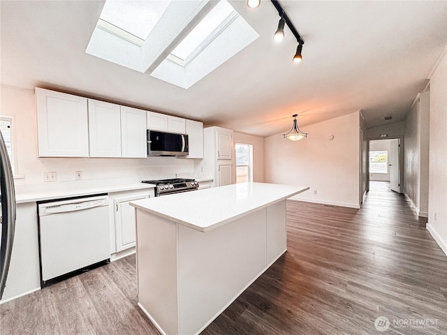 700 N Reed St Unit 72, Sedro Woolley, WA 98284 - kitchen featuring stainless steel appliances, a skylight, white cabinetry, light countertops, and vaulted ceiling