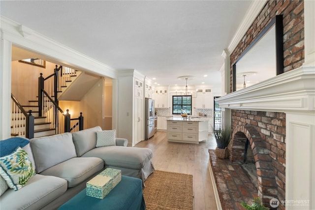 4217 Lakeridge Dr E, Lake Tapps, WA 98391 - living area featuring light wood finished floors, stairs, ornamental molding, a brick fireplace, and recessed lighting