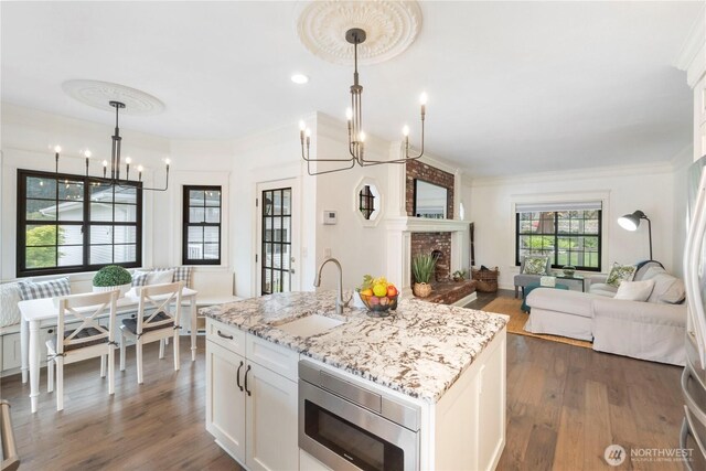 4217 Lakeridge Dr E, Lake Tapps, WA 98391 - kitchen featuring a chandelier, stainless steel microwave, a sink, open floor plan, and dark wood finished floors