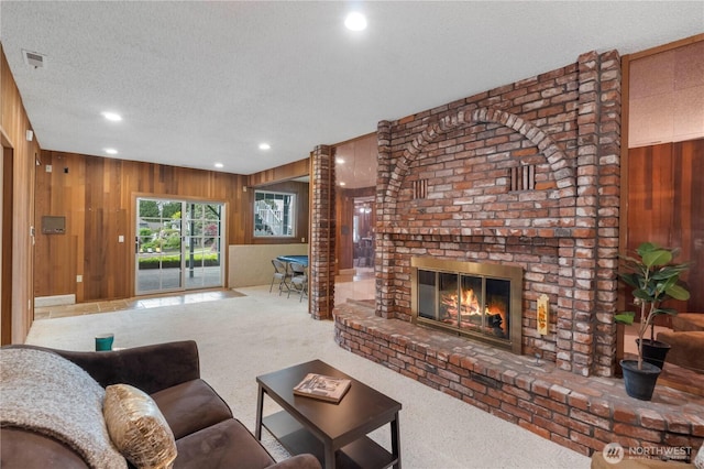 4217 Lakeridge Dr E, Lake Tapps, WA 98391 - living area featuring wooden walls, carpet floors, a textured ceiling, recessed lighting, and a brick fireplace