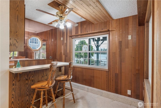 4217 Lakeridge Dr E, Lake Tapps, WA 98391 - indoor dry bar featuring wooden walls, a textured ceiling, a ceiling fan, and carpet flooring