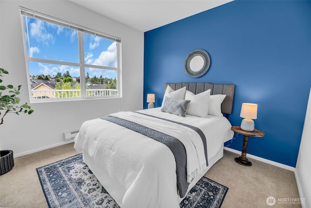bedroom with carpet, a baseboard heating unit, and baseboards