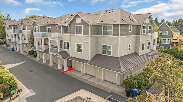 view of property with a residential view, a garage, and driveway