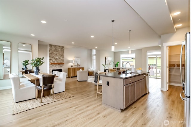 16001 1st Ave NE, Duvall, WA 98019 - kitchen with dark countertops, a sink, light wood finished floors, open floor plan, and a kitchen breakfast bar