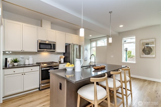 16001 1st Ave NE, Duvall, WA 98019 - kitchen featuring appliances with stainless steel finishes, a sink, dark countertops, light wood-style flooring, and recessed lighting