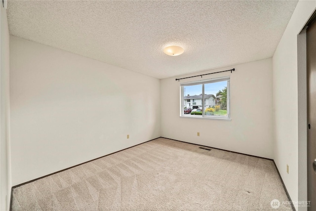 empty room featuring carpet flooring and a textured ceiling
