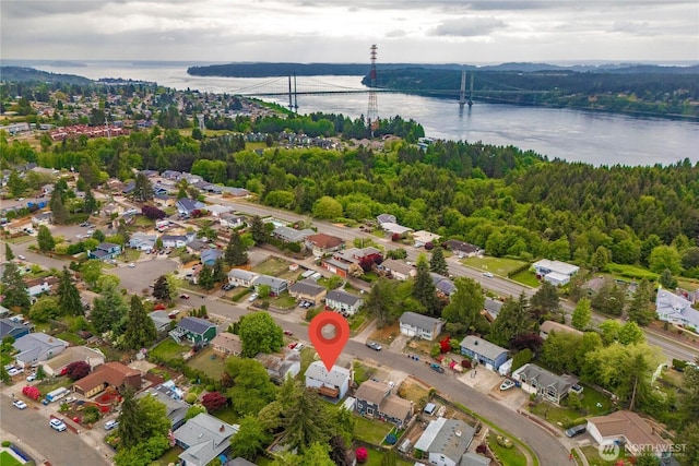 aerial perspective of suburban area featuring a notable bridge and a large body of water