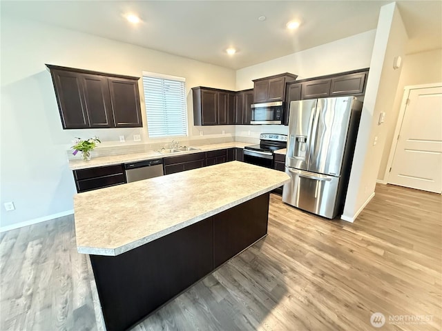 18708 108th Ave SE, Puyallup, WA 98374 - kitchen with appliances with stainless steel finishes, a sink, dark brown cabinets, light countertops, and baseboards