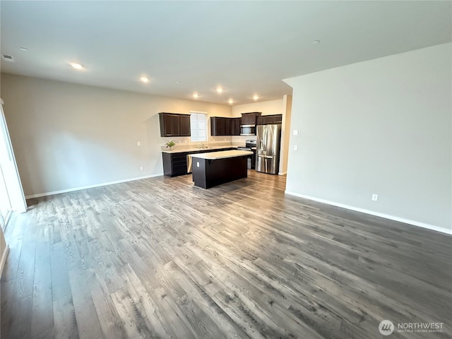 18708 108th Ave SE, Puyallup, WA 98374 - kitchen with appliances with stainless steel finishes, open floor plan, a center island, wood finished floors, and light countertops
