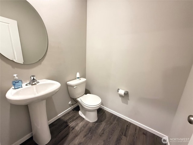 18708 108th Ave SE, Puyallup, WA 98374 - bathroom featuring toilet, baseboards, wood finished floors, and a sink