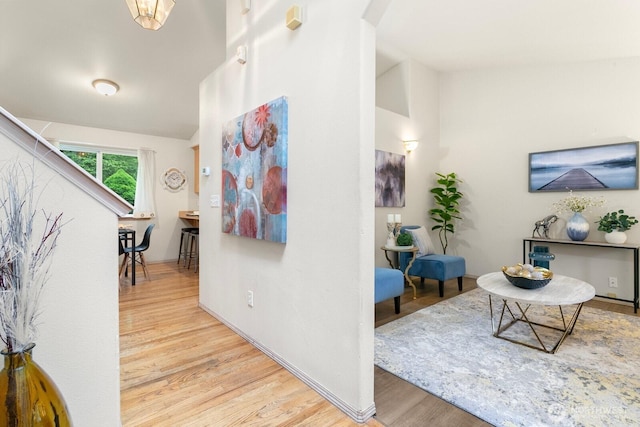 hall featuring wood finished floors, arched walkways, and lofted ceiling