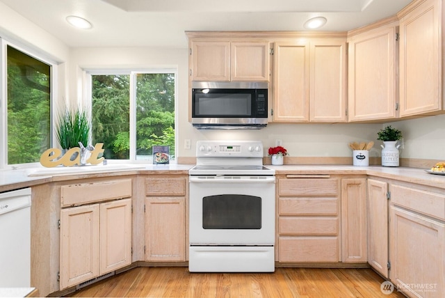 kitchen with white appliances, light brown cabinets, light countertops, recessed lighting, and light wood-style flooring